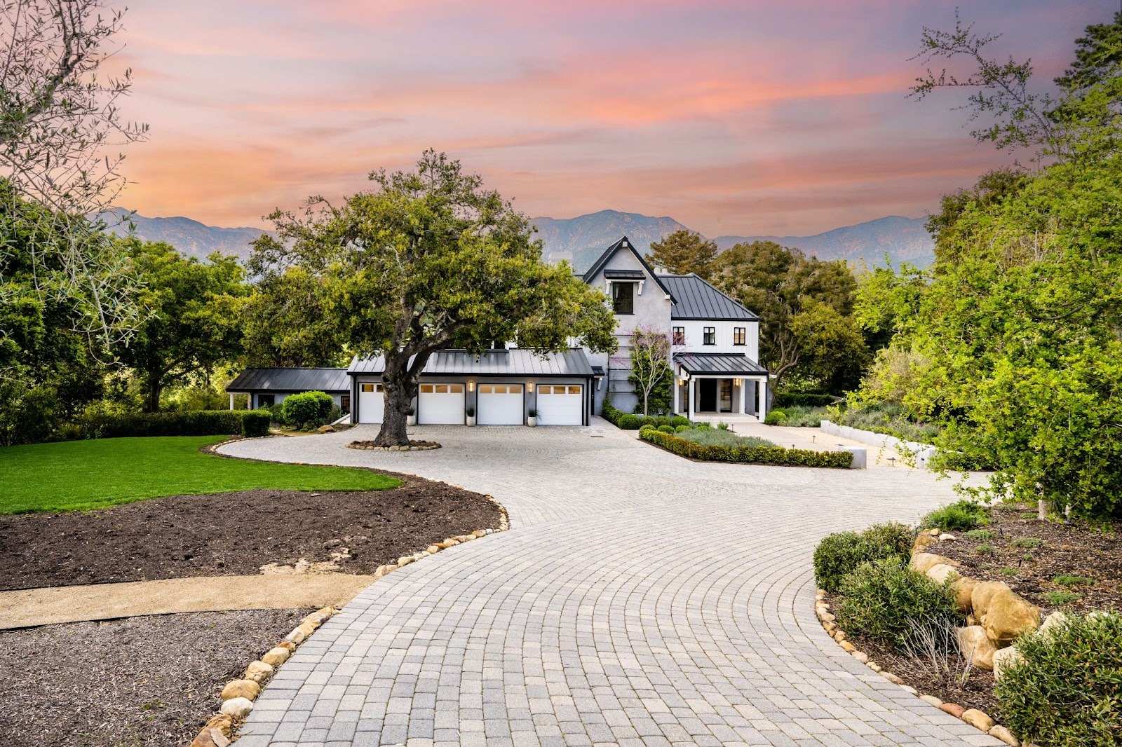 Elegant home featuring a freshly installed driveway amid a picturesque, green landscape